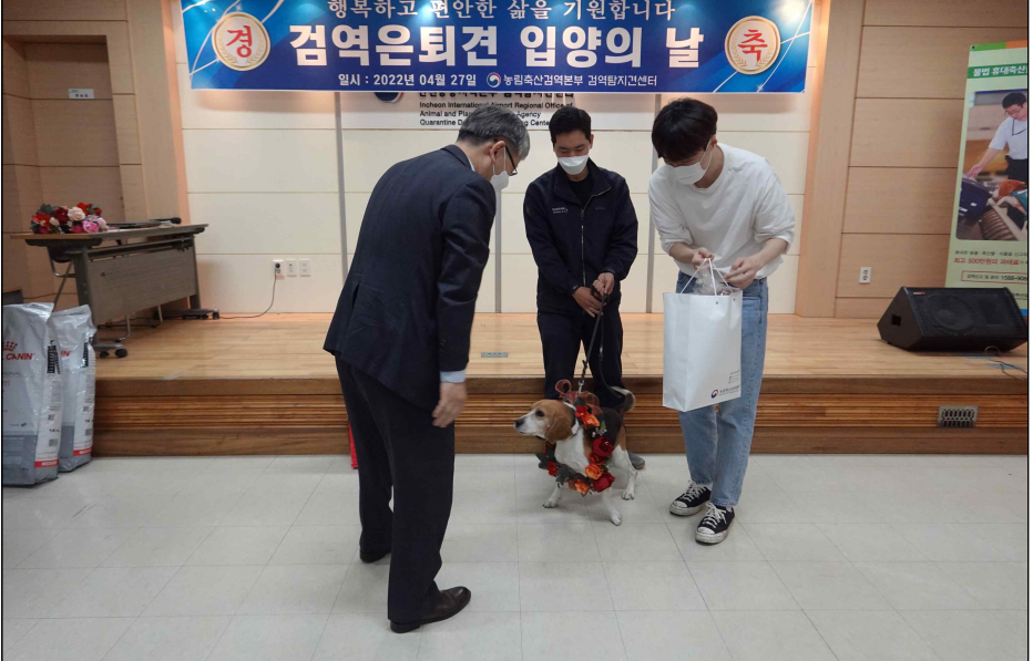 인천공항검역본부 이주명 본부장<사진 왼쪽>이 27일, 검역은퇴견들을 입양하는 새 부모들과 인사하며 은퇴견들을 인계했다. @사진은 인천공항검역본부 제공